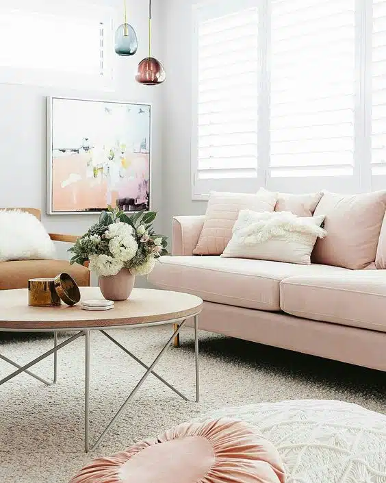 sofá rosa com mesa de centro e flores