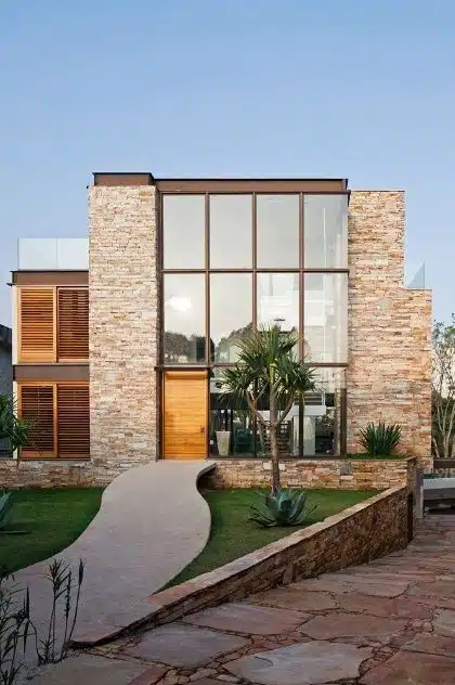 Fachada em harmonia com materiais rústicos, visando uma captação natural da luz solar