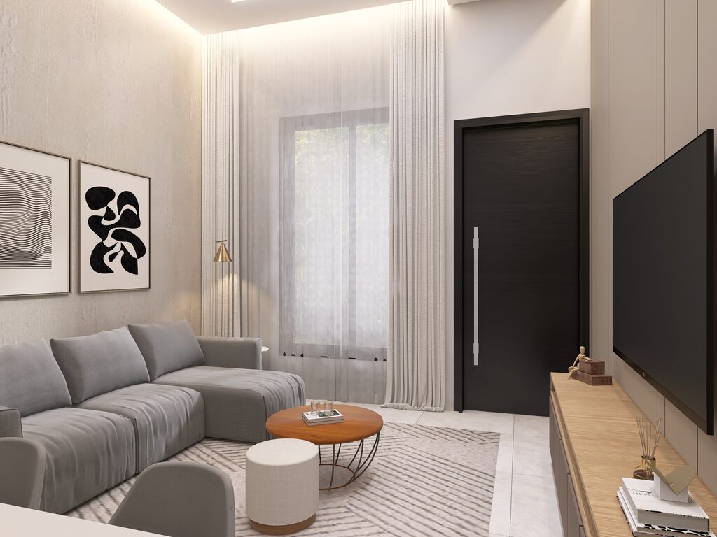 Sofá em sala pequena, com mesa pequena, televisão e quadros